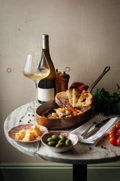 Title: Seafood stew with toasted bread, wine, olives, and cheese