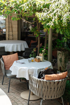 Outdoor restaurant table under tree canopy with cushioned chairs