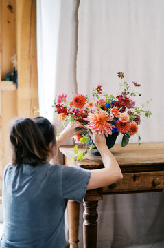 farmer designing a wedding bouquet with dahlia, cucamelon, flowers