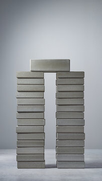 A stack of books forms an archway with another on top indoors