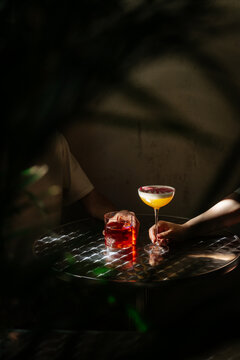 Two cocktails on metallic table in moody light