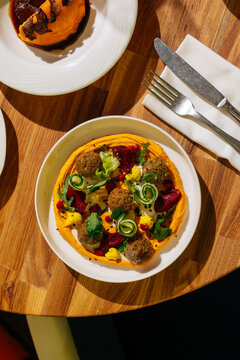 Hummus with falafel and colorful vegetable garnish