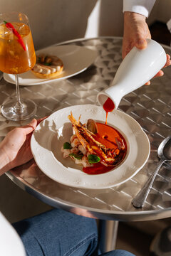 Seafood dish with prawn and red sauce being served