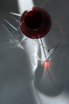 Title: Red wine glass with dramatic shadows - Description: Overh
