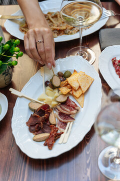 Charcuterie plate with cheese, cured meats, olives, and chips