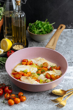 Orecchiette pasta with broccoli, tomatoes, and cheese in black pan
