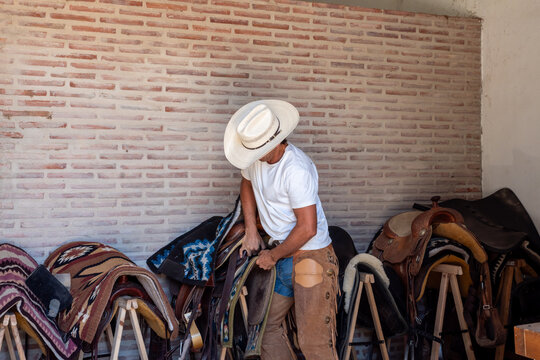 Cowboy Preparing Saddle Inside Andalusian Ranch
