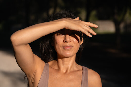 A happy woman enjoys the sun while protecting her eyes outdoors
