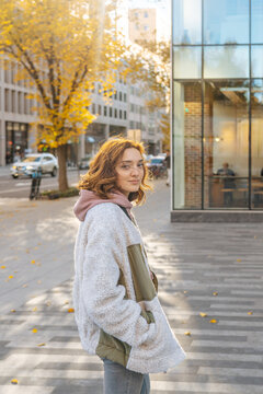 Woman in sherpa jacket standing on city street