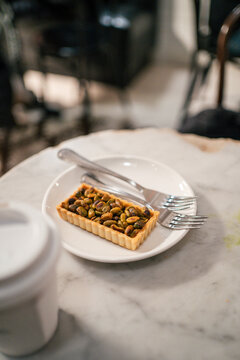Pistachio tart on white plate with cutlery