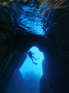 scubadivers are exploring caves underwater