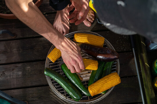 A hand grilling vegetables on a bbq 