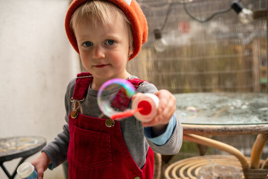 Little girl playing with bubbles 