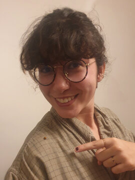 Woman with a large smile pointing at a ladybug 