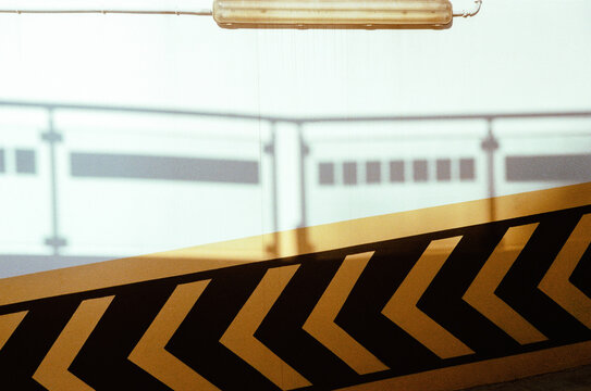 Geometric arrows and light on city wall