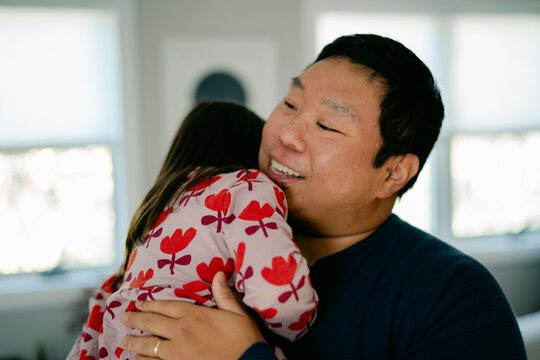 smiling father hugging his little girl 
