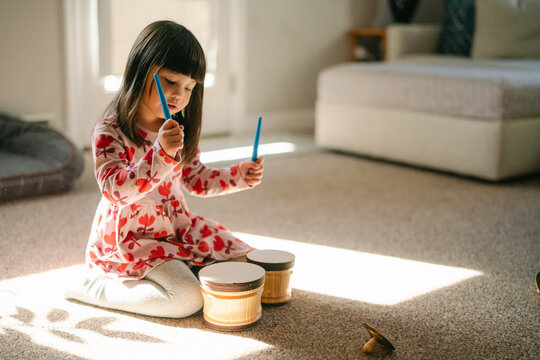 happy little girl singing and playing drums 