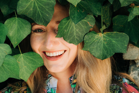 Uplifting female portrait framed by lush ivy leaves