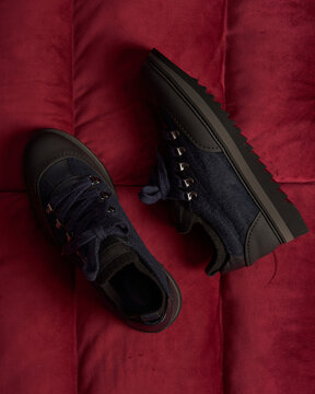  Close-up of navy blue wool sneakers with black leather accents. 