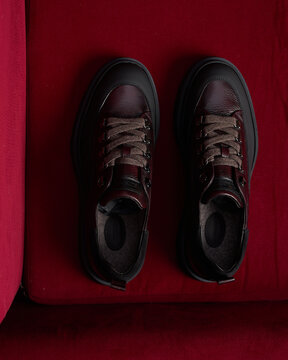 Top view of burgundy leather sneakers with brown laces