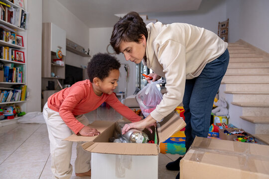 Mother and son opening a box of Christmas decorations at home