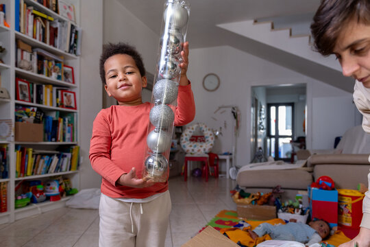 Boy excited to decorate the holiday tree with silver baubles