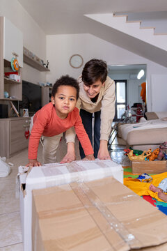 Mother and Son Working Together to place a Box in Living Room