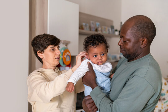 Family Interacts With Baby in Living Room During Day