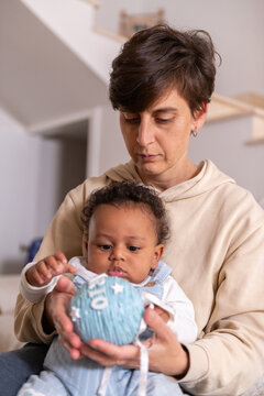 Mother and baby son looking at a blue Christmas ornament