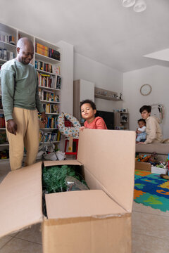 Family unboxing a Christmas tree together in their living room