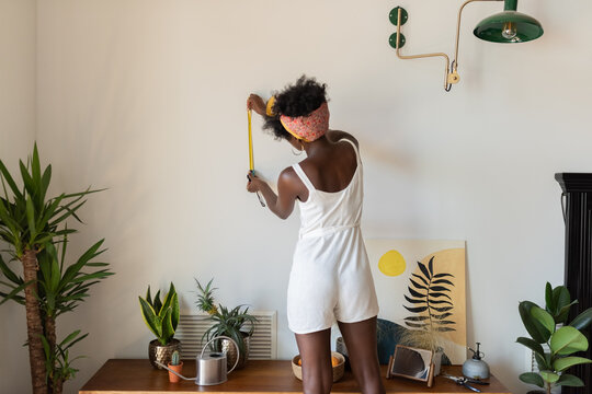Woman measuring wall
