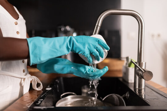 Woman rinsing bowl under tap water 