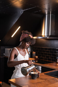 Woman pouring fresh coffee in her cup