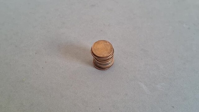 Human hand carefully balancing a small stack of golden coins in this detailed motion video clip