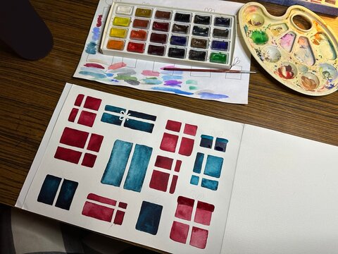 An artist's desk is in the process of painting a illustration.