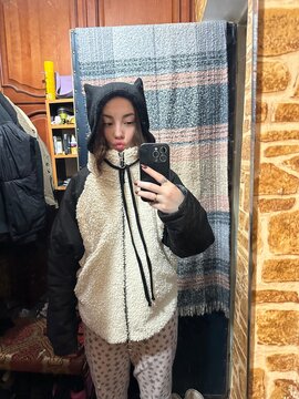 A funny mirror selfie of a young woman wearing a cute hat with ears