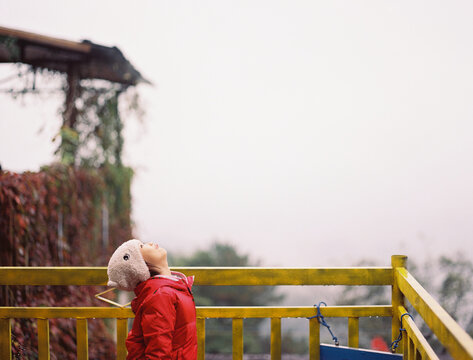 Chinese girl on a winter mountain cabin platform, Looking up