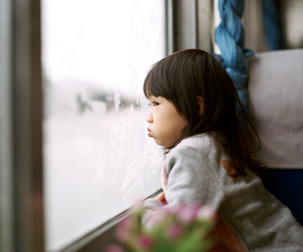 Chinese girl looking at the scenery from a train window in winter