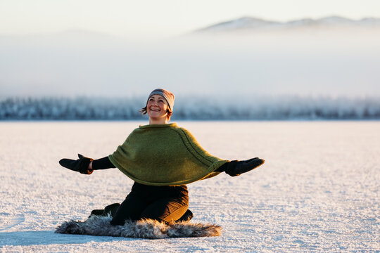 Woman expressing gratitude on winter lake