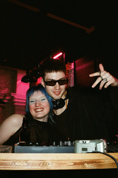 DJ With Sunglasses and Blue-Haired Friend at Decks, Pink Neon