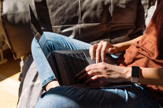 Person Typing On Laptop In Cozy Home