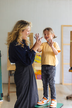 Mother And Child High-Fiving With Painted Hands