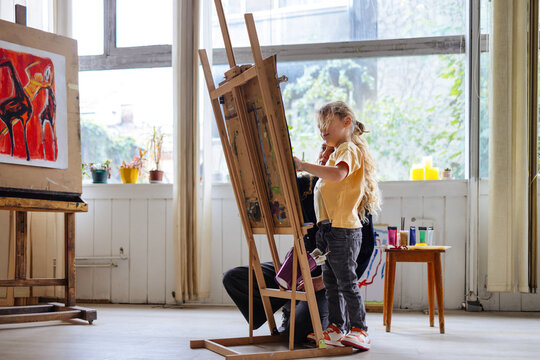 Little Boy Painting With Helper In Art Studio