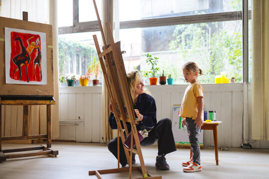 Artist Teacher With Child In Bright Art Studio
