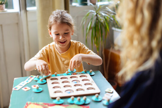 Boy Playing Board Game At Table With Pieces