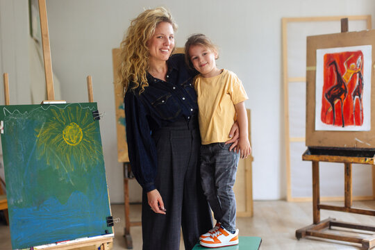 Mother and Child in Art Studio With Paintings