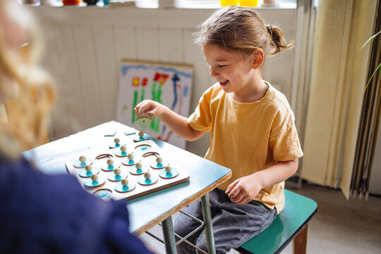 Happy Boy Plays Board Game At Table