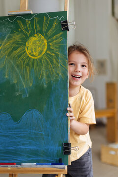 Happy Child Peeking From Chalkboard With Sun Drawing