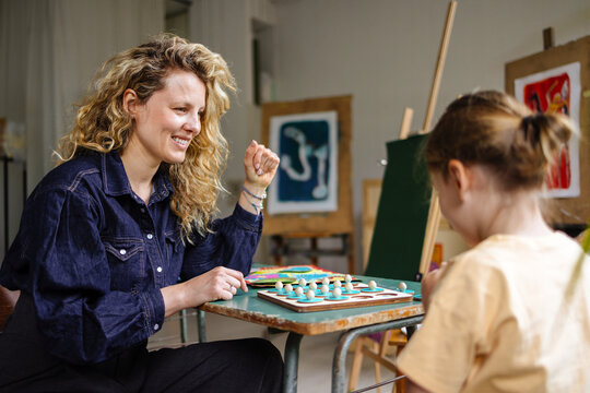 Woman and Child Playing Board Game in Art Studio