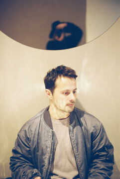 man in a nice light in a cafe and a mirror with a photographer